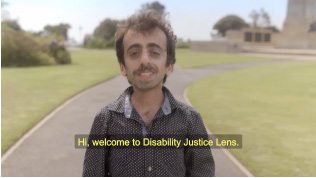 Comedian speaking to camera with subtitle 'welcome to the Disabilty Justice Lens'.