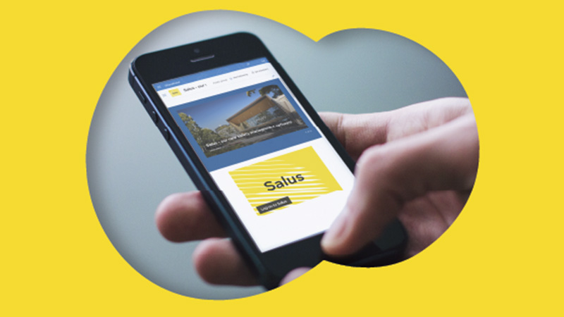 Hand holding a phone, open to an app called 'SALUS'.